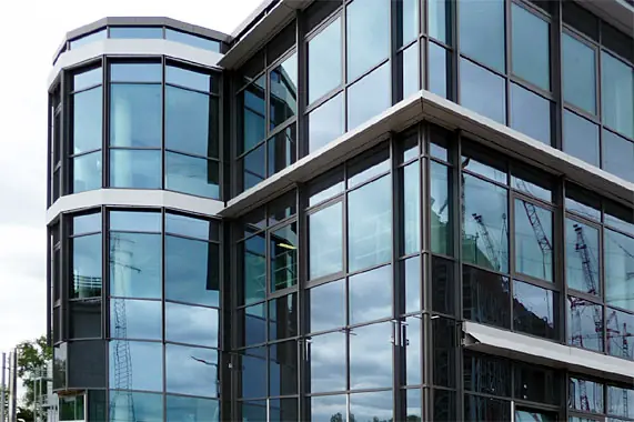 Glasfassade mit gerundeter Gebäudeecke – Montage durch Reiss Metallbau
