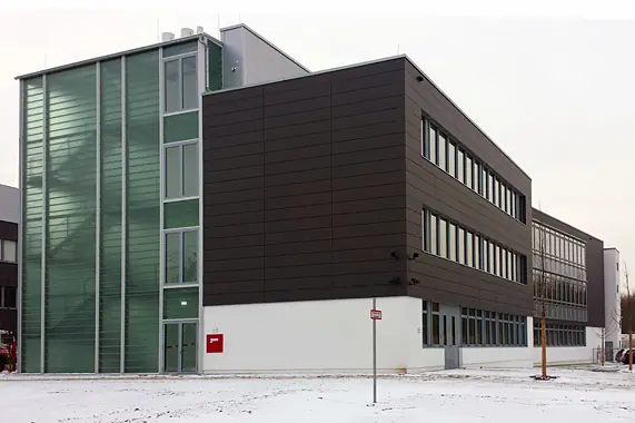 Verglastes Treppenhaus vor dunkler Blechfassade – Montage durch Reiss Metallbau